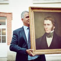 Olivier Krug mit einem Bild des Gründers Joseph Krug.