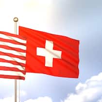 Flaggen der USA und der Schweiz wehen im Wind (2023).