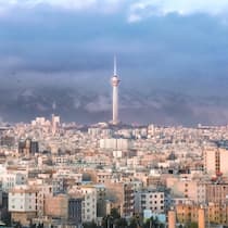 Tehran urban "skyline" with prominent "Milad tower" and air pollution hiding the "Alborz" mountain range ("Mount Tochal") in Tehran, Iran