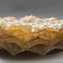 Die Blasen erhält der Teig durch das Ausrollen mit einem Nadelholz vor dem Frittieren.