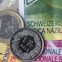 Euro- und Frankenmünze auf Schweizer Banknoten.