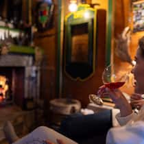 Vor dem Kaminfeuer ein Glas Rosé geniessen, während im Ofen die dazu passenden Bratäpfel schmoren, ist ein aussergewöhnliches Wintervergnügen.