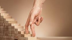 Eine Hand fährt über eine kleine Holztreppe