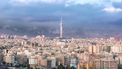 Tehran urban "skyline" with prominent "Milad tower" and air pollution hiding the "Alborz" mountain range ("Mount Tochal") in Tehran, Iran