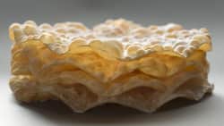 Die Blasen erhält der Teig durch das Ausrollen mit einem Nadelholz vor dem Frittieren.