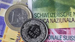 Euro- und Frankenmünze auf Schweizer Banknoten.