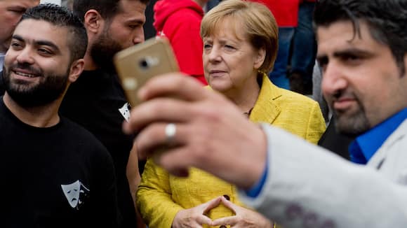 ARCHIV - 23.09.2017, Mecklenburg-Vorpommern, Greifswald: Syrische Flüchtlinge, die eine Theatergruppe gegründet haben, nehmen bei der Aktionswoche der Wiederbelebung ein Selfie mit Bundeskanzlerin Angela Merkel (CDU) auf. (zu dpa "Bedauern bis Erleichterung - Merkels Wahlkreis über Rückzug gespalten" am 31.10.2018) Foto: Stefan Sauer/dpa +++ dpa-Bildfunk +++ (KEYSTONE/DPA/Stefan Sauer)