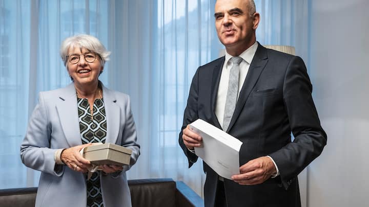 Bundespraesident Alain Berset, rechts, und seine Nachfolgerin Bundesraetin Elisabeth Baume-Schneider tauschen Geschenke aus, am Freitag, 22. Dezember 2023, in Bern. (KEYSTONE/Peter Schneider)