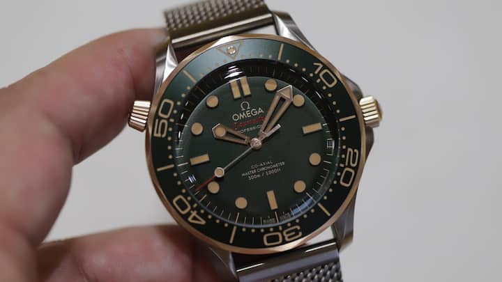 Die letzte, 2024 vorgestellte Variante der Seamaster Diver 300M verbindet erstmals ein mattes Titangehäuse, ein grünes Aluminium-Inlay und Zifferblatt mit Bronze-Gold für Krone, Heliumventil und Drehring. 