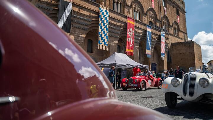 TRAUMHAFTE KULISSE Klassiker auf histori­ schem Pflaster. Im Hintergrund ein roter Fiat 110 (508 C) Sport von 1936, rechts ein BMW 328 von 1938.