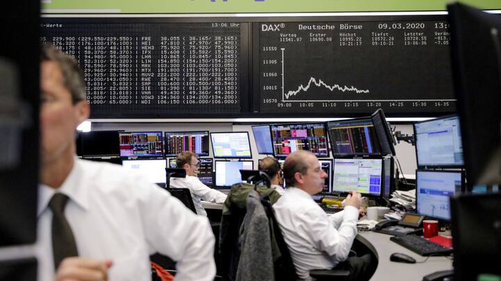 Traders monitor financial data near the DAX Index curve inside the Frankfurt Stock Exchange, operated by Deutsche Boerse AG, in Frankfurt, Germany, on Monday, March 9, 2020. Germanys DAX is set to enter a bear market amid drastic coronavirus containment measures in Italy and a crash in oil markets. Photographer: Alex Kraus/Bloomberg