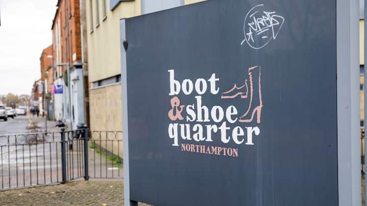 Schwarzes Schild mit der Aufschrift "boot & shoe quarter" in Northampton.