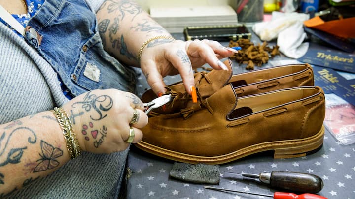 Mitarbeiterin stellt Schuhe fertig