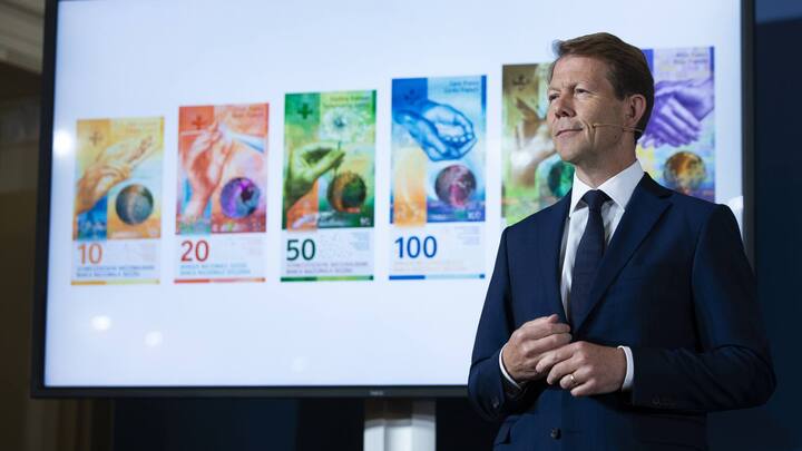Fritz Zurbruegg, Vice president of the Swiss National Bank, stands beside a screen showing the new series of Swiss banknotes during the presentation of the new Swiss 100 francs banknote in Bern, Switzerland, Tuesday, September 3, 2019. (KEYSTONE/Peter Klaunzer)