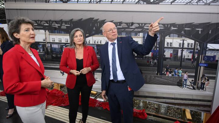 La Conseillere federale Simonetta Sommaruga, gauche, parle avec la conseillere d'Etat du canton de Vaud Nuria Gorrite, centre, et le CEO des CFF Vincent Ducrot, droite, devant une photographie geante representant la gare renovee lors du premier coup de pioche du chantier de la gare CFF de Lausanne, projet Leman 2030, ce mardi 29 juin 2021 a Lausanne. (KEYSTONE/Laurent Gillieron)