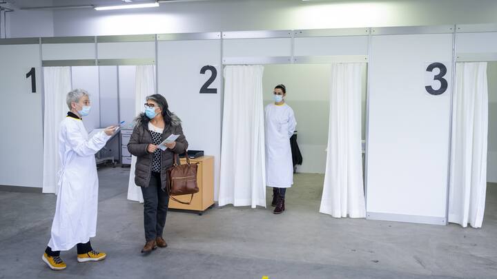 Une infirmiere parle avec une patiente apres une vaccination avec le vaccin Moderna lors de l'ouverture des centres de vaccination contre le Coronavirus (Covid-19) en Valais le mardi 2 fevrier 2021 a Sion. (KEYSTONE/Jean-Christophe Bott)