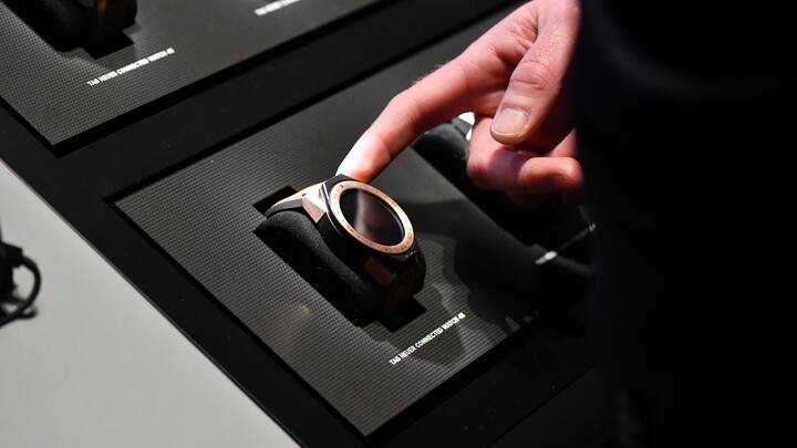 BASEL, SWITZERLAND - MARCH 23:  A visitor points a TAG Heuer Connected Watch 45 displayed at the BaselWolrd watch fair on March 23, 2018 in Basel, Switzerland. The annual watch trade fair sees the very latest horological designs unveiled from companies from all over the world.  (Photo by Harold Cunningham/Getty Images)