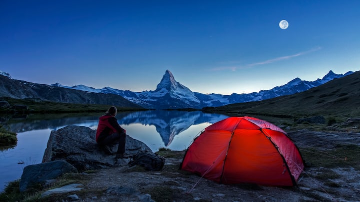 An illuminated tent  under full Moon at Matterhorn in Switzerland