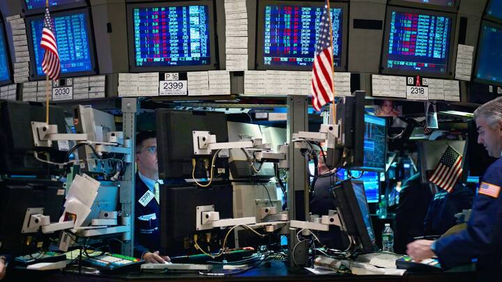 Traders work in front of computers on the floor of the New York Stock Exchange.