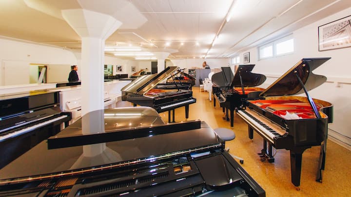 Mehrer Klaviere Rätia 132 in einem Ausstellungsraum.