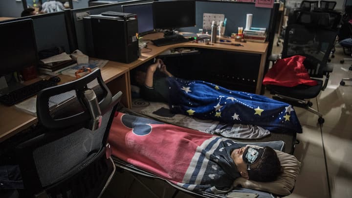 Huawei employees sleep at their cubicle during their lunch break, which is known to be common practice in many workplaces in China, at the research and development area in the Bantian campus on April 12, 2019, in Shenzhen, China.