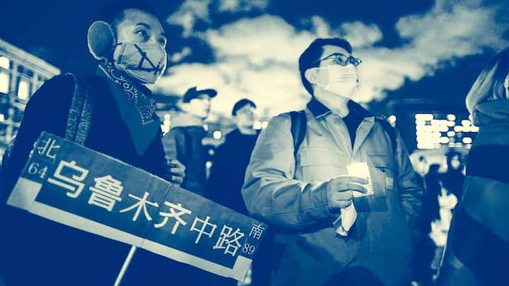 A man holds a candle as people gather at Columbia University during a protest in support of demonstrations held in China calling for an end to Covid-19 lockdowns, in New York on November 28, 2022. - People have taken to the streets in major cities and gathered at university campuses across China in a wave of nationwide protests not seen since pro-democracy rallies in 1989 were crushed. (Photo by KENA BETANCUR / AFP)