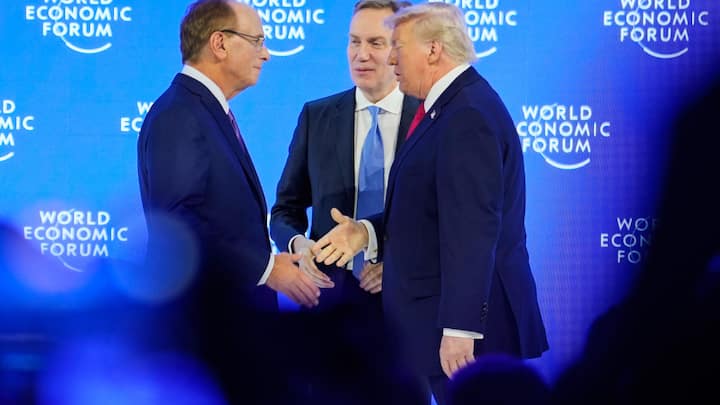 President Donald Trump is welcomed by Forum's President Borge Brende and Forum's Co-Chair Larry Fink on the podium before his speech during the Annual Meeting of the World Economic Forum in Davos, Switzerland, Wednesday, Jan. 21, 2026. (AP Photo/Markus Schreiber)