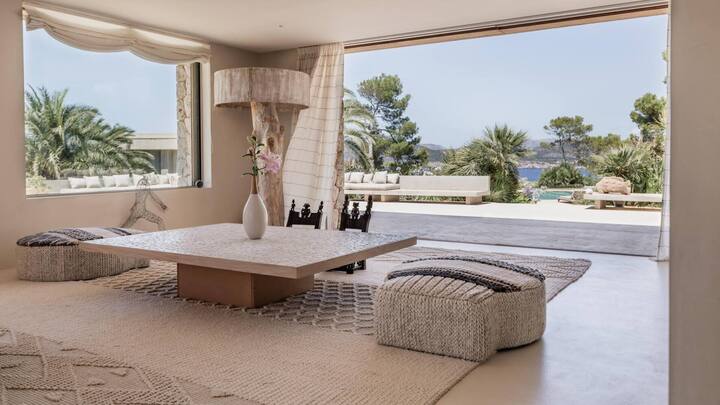 Blick aus dem Wohnzimmer mit grossen Fenstern und weit öffnenden Terrassentüren.