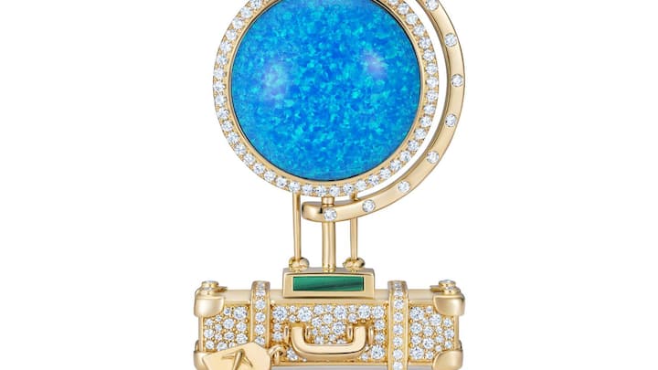 «All around the World»-Globus aus Opal auf einem goldenen Köfferchen.