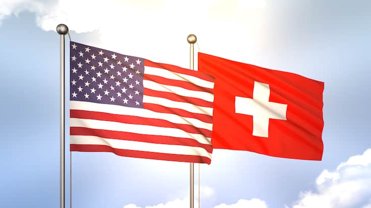 Flaggen der USA und der Schweiz wehen im Wind (2023).