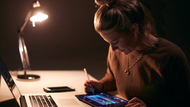 Eine junge Börsenhändlerin verfolgt Aktienkurse am PC.