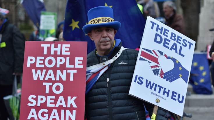 An anti Brexit protester holds placard saying "The people want to speak again and The best deal is with the EU" outside the Houses of Parliament 