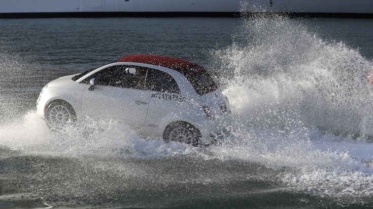 A Fiat 500 watercraft goes through the water as it escorts the MSC Divina cruise ship arrives at the Port of Miami, Tuesday, Nov. 19, 2013, in Miami. This is the ship's North American debut since departing Venice, Italy Nov. 2. The Divina will offer year-round Caribbean sailings from its home port of Miami. (AP Photo/Lynne Sladky)