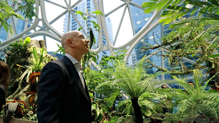 Jeff Bezos, the CEO and founder of Amazon.com, takes a walking tour of the Amazon Spheres, three plant-filed geodesic domes that serve as a work- and gathering place for Amazon employees, following a grand opening ceremony, Monday, Jan. 29, 2018, in Seattle. (AP Photo/Ted S. Warren)