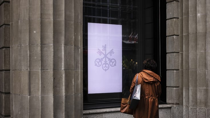 A woman looks at a screen at the entrance of the headquarters of the Swiss bank UBS in Zurich, Switzerland, on Friday, March 24, 2023. (KEYSTONE/Michael Buholzer).