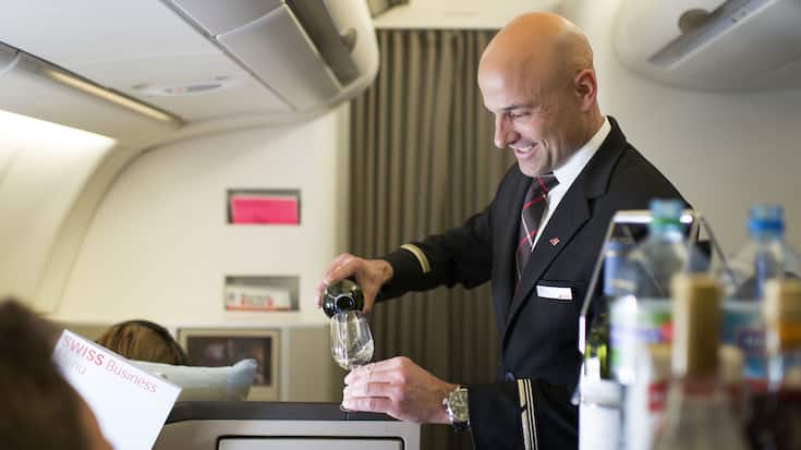 A flight attendant attends to the Business Class passengers, pictured on April 29, 2013 in an aircraft of Swiss. Swiss, short for Swiss International Air Lines, flies from Zurich to Chicago and back. (KEYSTONE/Christian Beutler)Ein Flugbegleiter bedient die Passagiere der Business Class, aufgenommen am 29. April 2013 in einem Flugzeug der Swiss. Die Schweizer Fluggesellschaft Swiss fliegt von Zuerich nach Chicago und zurueck. (KEYSTONE/Christian Beutler)