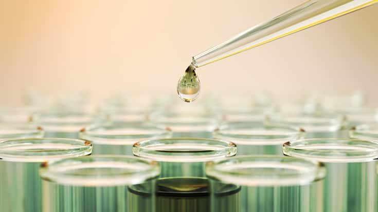 Testing Liquid from Green Glass Pipette into Test Tubes on Yellow Reflective Background