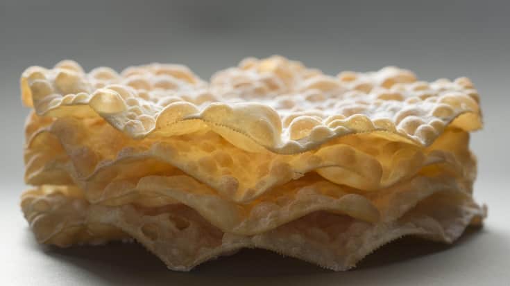 <p>Die Blasen erhält der Teig durch das Ausrollen mit einem Nadelholz vor dem Frittieren.</p>