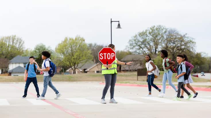 Crossing guard assisting school children