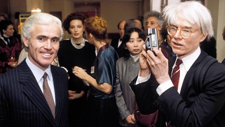 Andy Warhol (rechts) ist kurz davor, Yves Piaget an einem Event zu fotografieren (Washington DC, 1984). 
