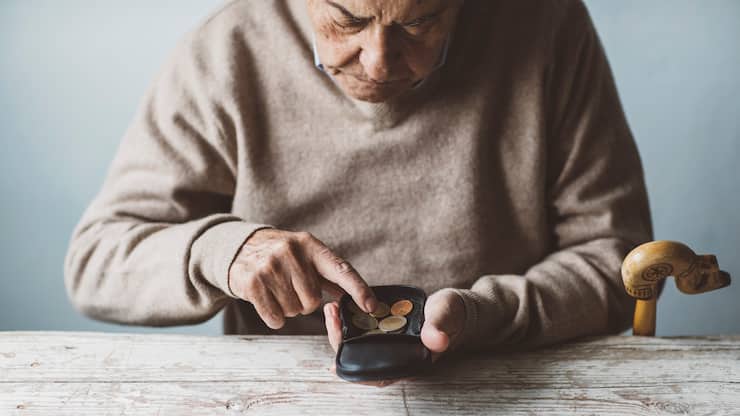 Ein Rentner zählt seine wenigen Münzen im Geldbeutel