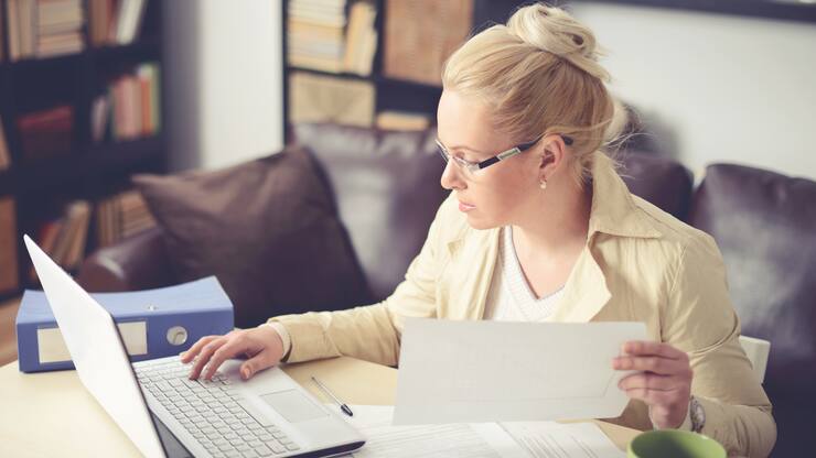 Frau am PC füllt Steuererklärung aus