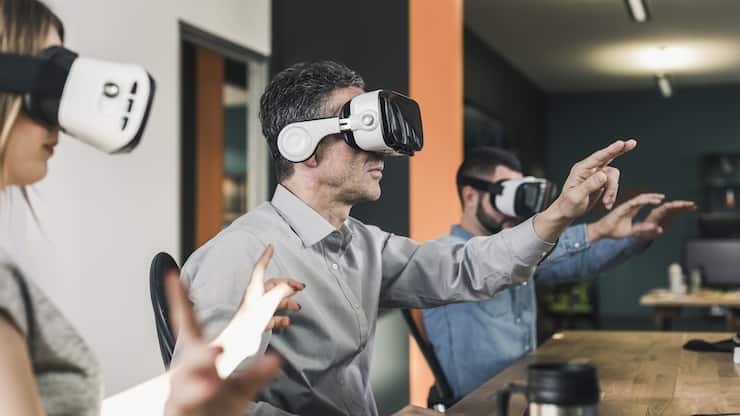 Colleagues wearing VR glasses in office