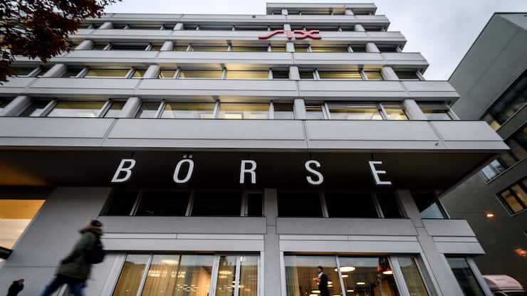 People walk in front of the headquarters of the Swiss Stock Exchange (Boerse) operated by the SIX group in Zurich on November 29, 2018. - According to a EU Commission document, for now, not enough progress on the Swiss-EU framework agreement has been made to renew the 'financial equivalency' status of the Swiss stock exchange in Europe, media reported on November 28, 2018. (Photo by Fabrice COFFRINI / AFP)