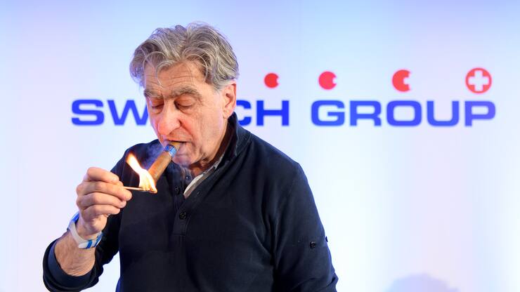 Nick Hayek, CEO Swatch Group, President of the Swatch Group Executive Management Board lights his cigar during a press conference of the year 2017 final results of Swiss watch company Swatch Group, in Biel, Switzerland, this Wednesday, March 14, 2018. (KEYSTONE/Anthony Anex)