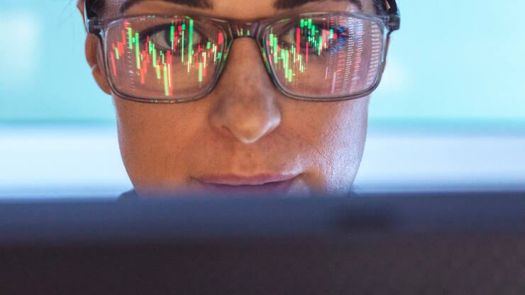 Stockbroker analyzing financial stock market with reflection on eyeglasses