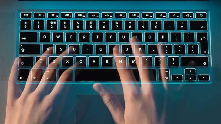 Hands of hacker coding computer virus on laptop