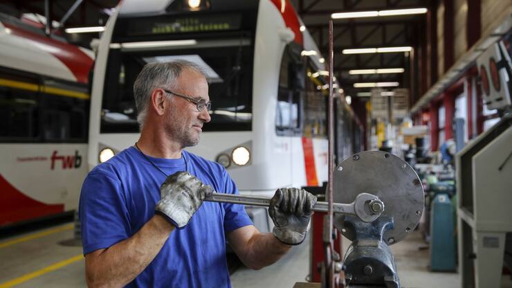 An employee services components at the Stadler Rail AG service facility in Wil, Switzerland, on Tuesday, Oct. 8, 2019. Stadler, a Swiss manufacturer of trains and trams, is on track to double its annual turnover to 4 billion francs ($4 billion) by next year, compared with 2018, without having to resort to big acquisitions thanks to a full order book, billionaire chairman and majority shareholder Peter Spuhler said in an interview with Finanz und Wirtschaft. Photographer: Stefan Wermuth/Bloomberg