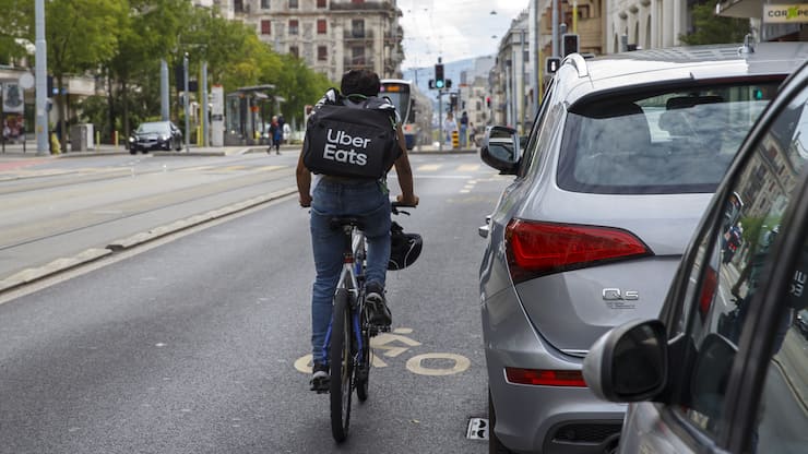 Un coursier partenaire de la societe Uber Eats roule en ville de Geneve avec un velo pour livrer des repas a domicile, ce lundi 19 aout 2019 a Geneve. (KEYSTONE/Salvatore Di Nolfi)