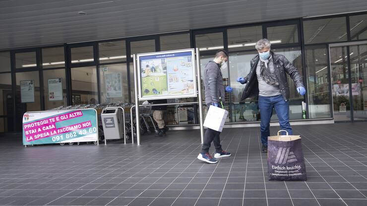 Die Freiwilligenhelfer Adem Salimi, links, und Angelo Vellani, rechts, machen Einkaeufe fuer eine betagte Person, am Montag, 23. Maerz 2020, in Biasca. Aufgrund des Coronavirus verzichten viele aeltere Personen darauf, selber Einkaeufe zu taetigen. (KEYSTONE/Ti-Press/Pablo Gianinazzi)